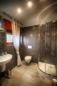 ein Bad mit einer Dusche, einem WC und einem Waschbecken in der Unterkunft Wunderkammer b&b in Pulsano