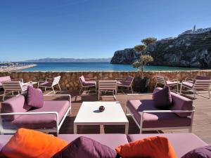 un patio con sillas, mesas y el océano en Mercure Quemado Al-Hoceima Resort, en Alhucemas