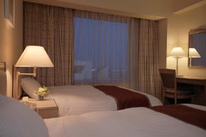 Postel nebo postele na pokoji v ubytování Miyako Hotel Yokkaichi