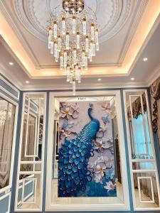 a large blue peacock painting on a wall with a chandelier at Kinmen Happiness Shop in Jinning