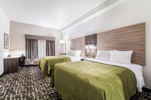 a hotel room with two beds with green sheets at Quality Inn & Suites Augusta I-20 in Augusta