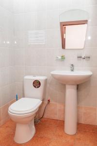 a bathroom with a toilet and a sink at GYM Inn in Tashkent