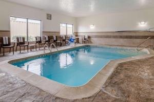 a pool in a hotel room with chairs and a table at Comfort Suites Speedway - Kansas City in Kansas City