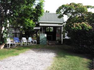 a group of chairs sitting outside of a house at Whitianga Campground in Whitianga +7 photos