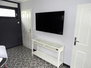 Ferienhaus mit Garten في غرال موريتز: غرفة معيشة مع تلفزيون بشاشة مسطحة على جدار