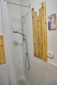a shower with a wooden door in a bathroom at e ci rivò su in Licodia Eubea