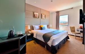 a hotel room with a large bed and a desk at Serela Merdeka by KAGUM Hotels in Bandung