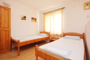 Habitación con 2 camas y ventana en Apartments Adria, en Orebić