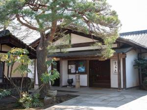 un bâtiment avec un arbre en face dans l'établissement Nagataki, à Nakatsugawa