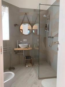 La salle de bains est pourvue d'une douche en verre et d'un lavabo. dans l'établissement Il Belvedere, case vacanza, à Laterza