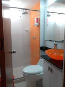 a bathroom with a toilet and a sink at Supercondo Home Away From Home mi Casa Tu Casa in Cali