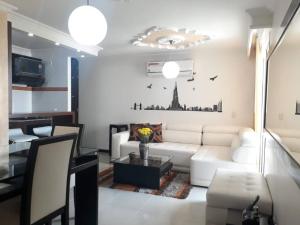 sala de estar con sofá blanco y mesa en Supercondo! Home Away From Home (mi Casa Tu Casa), en Cali