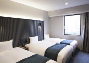 a hotel room with two beds and a window at THE KNOT TOKYO Shinjuku in Tokyo