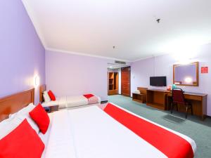 1 dormitorio con 1 cama y escritorio con TV en OYO 472 Comfort Hotel 1 en Klang