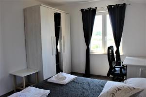 sypialnia z łóżkiem, biurkiem i oknem w obiekcie Horizont Apartman w mieście Kukci