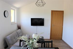 salon z kanapą i stołem w obiekcie Horizont Apartman w mieście Kukci
