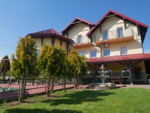 un gran edificio con una fuente en el patio en Dom Weselny Bartpol Family&SPA, en Gródek Nad Dunajcem