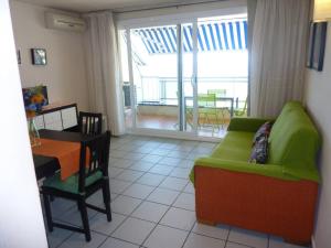 a living room with a green couch and a table at Primera Linea de Mar Portaventura in Salou