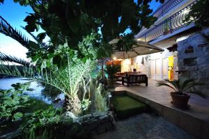 a house with a patio with plants and a pond at Apartments Villa Hraste Hvar in Hvar