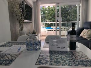 - Botella de vino en la mesa de la sala de estar en Vistamar Beach Luxury - 1ª Línea De Playa En Torre del Mar, Piscina y Apartamiento, en Torre del Mar