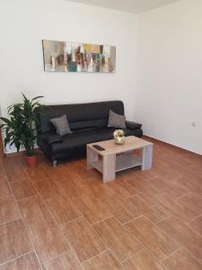 a living room with a black couch and a coffee table at Apartment ALEKSANDAR in Kotor