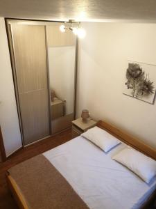 1 dormitorio con cama y espejo grande en Apartment ALEKSANDAR, en Kotor