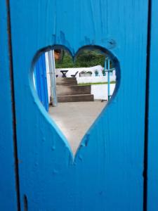 una puerta azul con un agujero en forma de corazón en Kékfestő Vendégház en Bükkszentkereszt