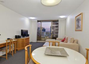 a living room with a table and a couch at Summit Apartments in Brisbane