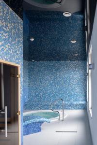 Baño azul con bañera con azulejos azules en Przystanek Alaska, en Zieleniec