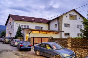 two cars parked in front of a house at Lavand House in Vişeu de Sus