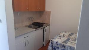 a small kitchen with a sink and a counter at Apartmani Lupi 2 M&S in Vrboska