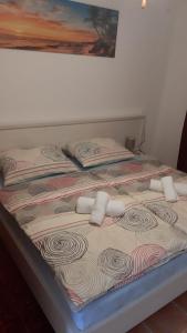 a bed with two pillows on top of it at Apartmani Lupi 2 M&S in Vrboska +9 photos
