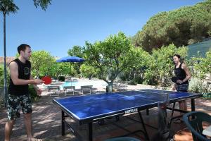 un homme et une femme debout autour d'une table de ping-pong dans l'établissement Elba Vip, à Porto Azzurro