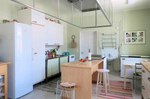 a kitchen with green walls and white appliances at Kuuksenkaari in Ilomantsi