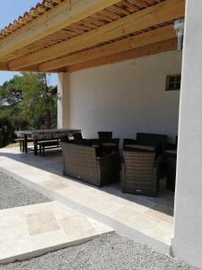 une terrasse avec une table et des chaises sous une pergola en bois dans l'établissement villa 12 personnes a lorgues, à Lorgues