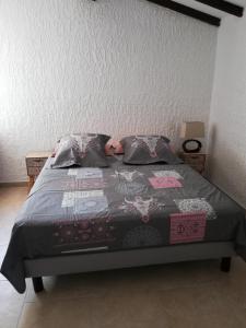 - un lit avec une couverture et des oreillers dans l'établissement villa 12 personnes a lorgues, à Lorgues
