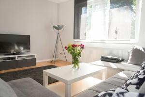a living room with a vase of flowers on a table at Location 1 in Rimschweiler