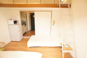 een kamer met een stapelbed en een ladder bij Plusone Fujisaki in Fukuoka