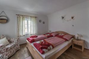 ein Schlafzimmer mit einem Bett, einem Sofa und einem Fenster in der Unterkunft Haus Steinhof in Sankt Lorenzen ob Murau