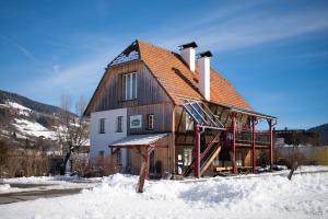 een houten huis in de sneeuw met sneeuw bij Haus Steinhof in Sankt Lorenzen ob Murau