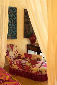 a couch with a book on it in a room with windows at Mas de la Chapelle in Arles