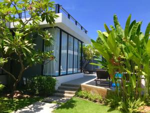 a house with glass windows and plants at Coco Layma Villa, Samui in Lamai