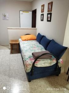 uma cama com almofadas azuis e uma mesa num quarto em Didi Guest House em Bete-Seã