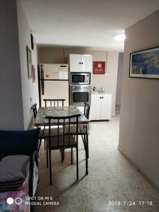 eine Küche und ein Esszimmer mit einem Tisch und Stühlen in der Unterkunft Didi Guest House in Bet Scheʼan