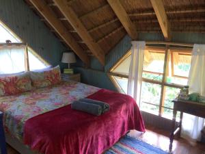a bedroom with a bed in a room with windows at Driftwood Treehouse in Sunrise-on-Sea