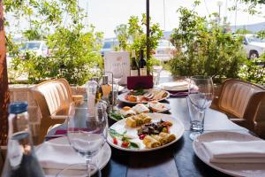 a table with plates of food and wine glasses at Waikiki Apartments in Tivat