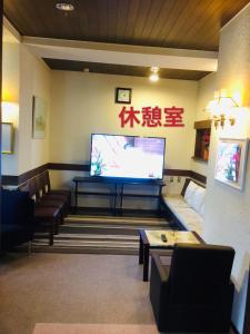 ein Wohnzimmer mit einem TV und einem Sofa in der Unterkunft 白樺湖榮園 in Chino