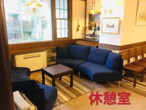 茅野的住宿－白樺湖榮園，客厅配有蓝色的沙发和桌子