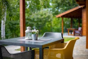 a table with chairs and a bottle and flowers on it at Friends Bungalows in Kŭrdzhali