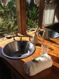 a sink in a wooden counter with a window at Driftwood Treehouse in Sunrise-on-Sea